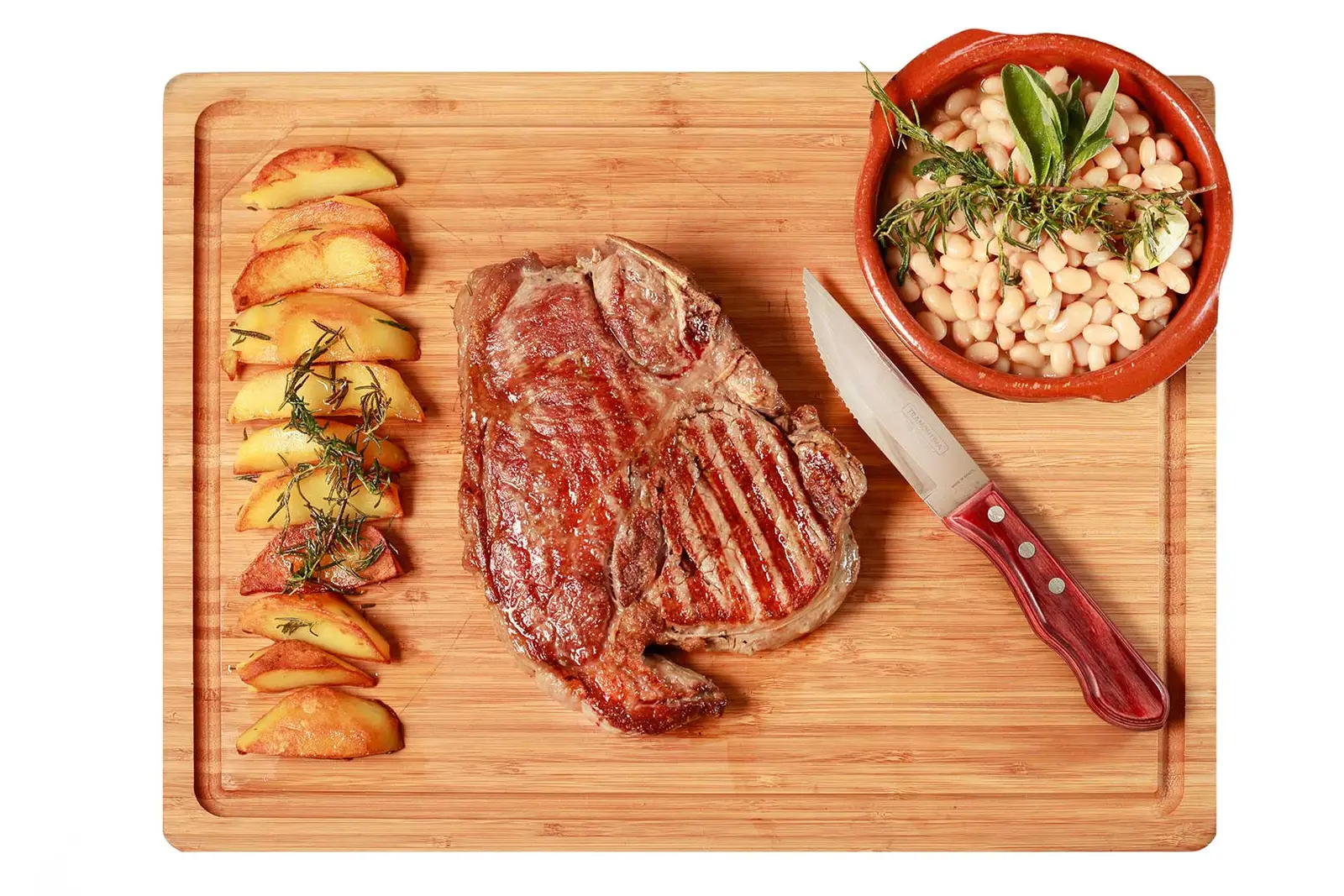 Gegrilltes Steak auf dem Holzbrett mit Bratkartoffeln, weißen Bohnen und Messer.