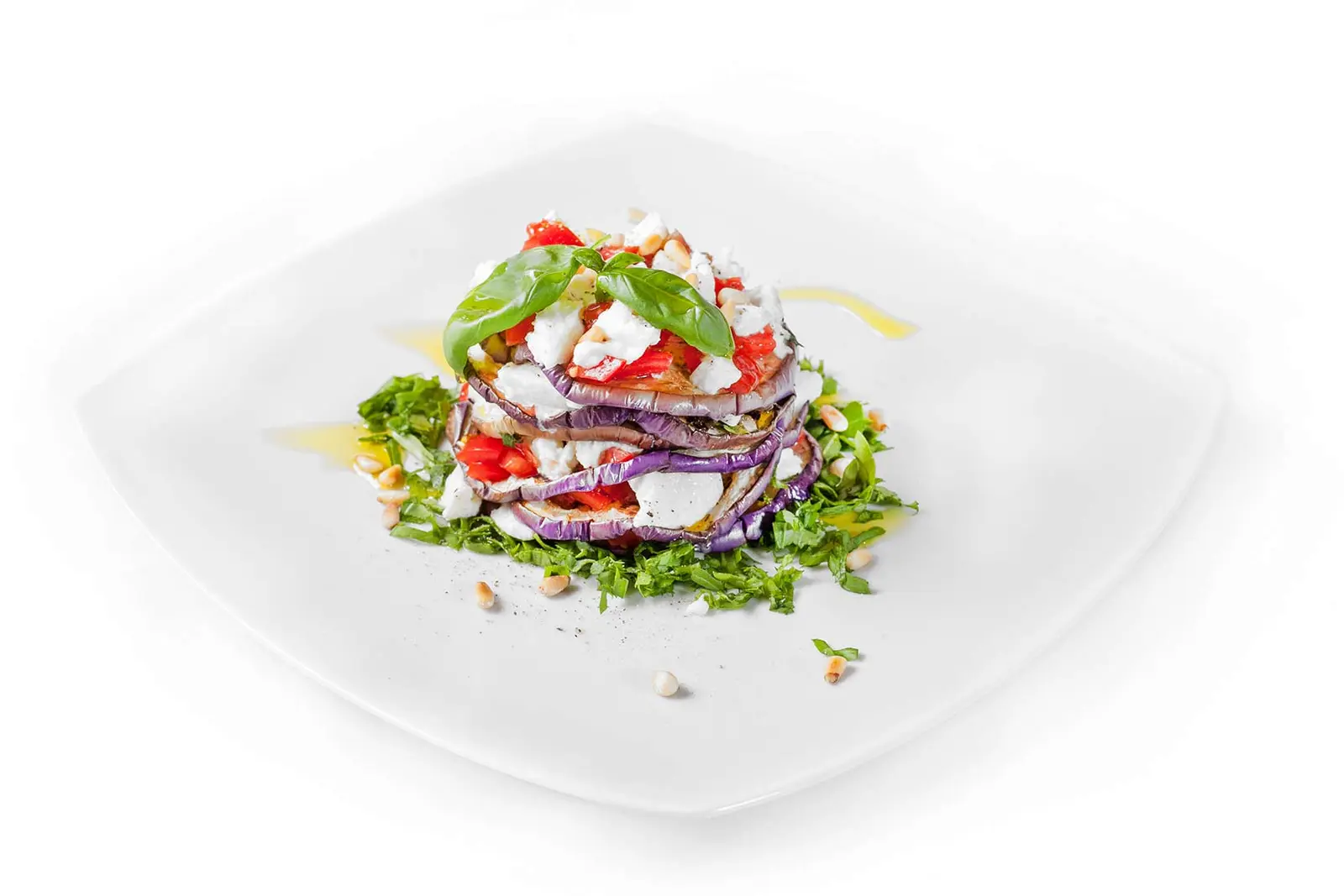 Geschichtete Auberginen mit Tomate und Rucola.